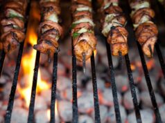 Chicken Skewers with Lemony Couscous: A Delicious Summer BBQ Option Grilled chicken skewers served over lemony couscous, gathered around a summer outdoor table with family and friends