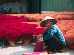 Reviving Morocco’s Rich Artisanal Heritage: A Celebration for Maghrebi Diaspora Woman admiring Moroccan artisan crafts, supporting the revival of Morocco's artisanal heritage