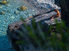 Exploring the Culture of the Amazigh People in ‘Welcome to 2976 Amazigh woman in traditional attire, holding a graphic novel titled 'Welcome to 2976'