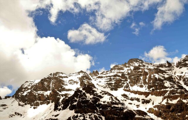 Jebel Toubkal hike peak Hikers scaling Jebel Toubkal with Atlas Mountains in the background
