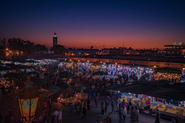 Woman walking in traditional Moroccan market with Condé Nast Traveller magazine