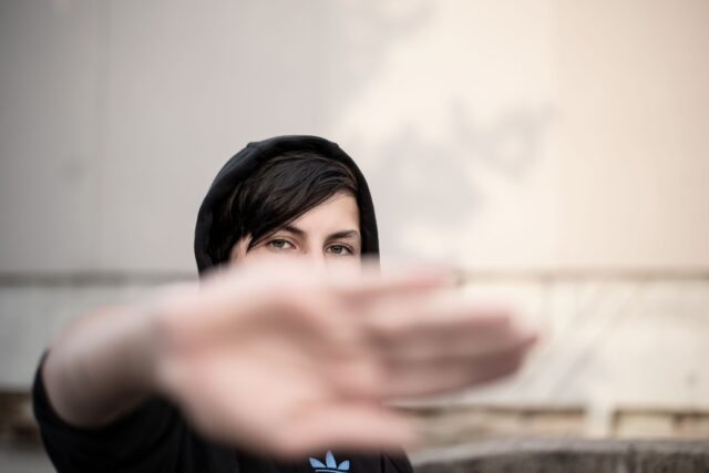 Young Maghrebi woman wearing modern streetwear outfit with traditional Moroccan elements in a digital cityscape