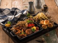 Bahraini Fusion Cuisine: A Modern Blend of Arabic, Iranian, and Indian Flavors Family enjoying Bahraini fusion dish at a vibrant outdoor restaurant