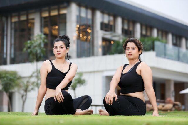 Maghrebi woman practicing yoga outdoors with a group of friends