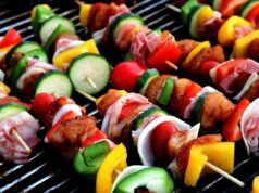Lemony Chicken Skewers with Maghrebin-Style Couscous: A Game-Changer for the Maghrebi Diaspora Lemony chicken skewers served on a plate with Maghrebin-style couscous, a colorful table setting, and a group of people enjoy