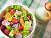 Fresh Quinoa Salad with Algerian Harissa Dressing – A Delicious Addition to Your Summer BBQs Fresh quinoa salad served on a wooden platter, garnished with herbs and drizzled with harissa dressing at an outdoor summer B