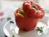 Spiced Couscous-Stuffed Peppers: A Delicious Moroccan Dish Spiced couscous filling stuffed inside colorful bell peppers on a wooden platter