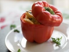 Spiced Couscous-Stuffed Peppers: A Delicious Moroccan Dish Spiced couscous filling stuffed inside colorful bell peppers on a wooden platter