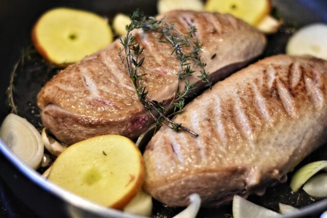 Tunisian spiced duck breasts Tunisian spiced duck breasts served with mandarin oranges and dates on a wooden cutting board