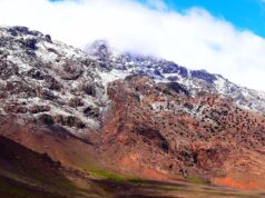 Unraveling Amazigh Culture in Morocco: Challenges, Opportunities, and a Path Forward Woman wearing traditional Amazigh attire amidst Atlas Mountains in Morocco