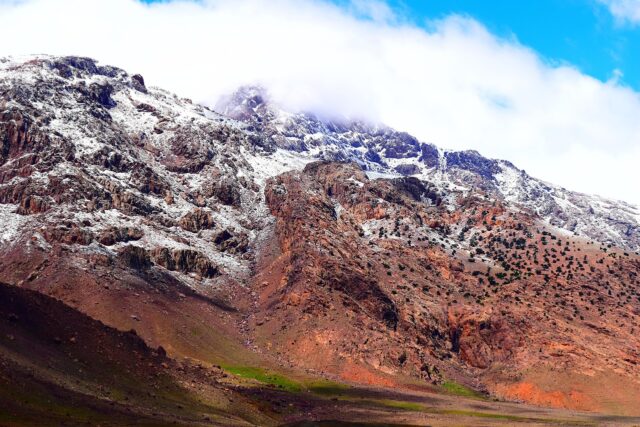 Amazigh woman in traditional attire Atlas Mountains Woman wearing traditional Amazigh attire amidst Atlas Mountains in Morocco