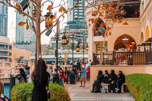 Confident Arab Woman - Diverse City Arab woman posing confidently in traditional Maghrebi attire against a backdrop of diverse global cityscape