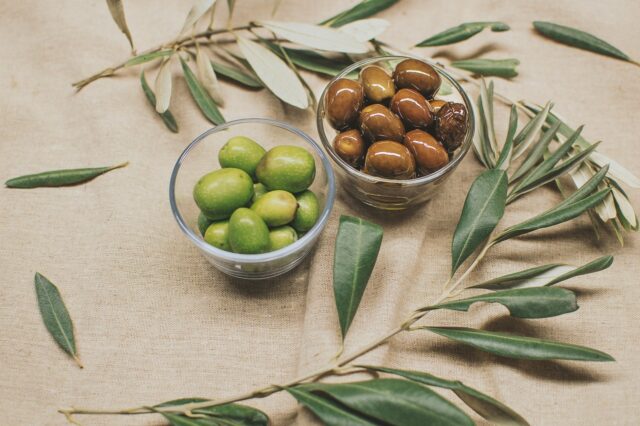 Vijaya Selvaraju serving a vibrant green goddess asparagus couscous salad on a rustic wooden table