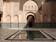 Beyond Cuisine: Exploring Artisanal Craftsmanship Preserved in Moroccan Workshops Artisan working on intricate Moroccan zellige tile in traditional workshop
