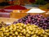 Reconnecting with Tangier: A Journey through Authentic Local Experiences Woman exploring Tangier medina with local food and spices market in the background