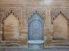 Discovering Morocco’s Rich Judeo-Amazigh Cultural Heritage: A Journey Through Time Woman wearing traditional Amazigh attire amidst Moroccan marketplace with Jewish artifacts