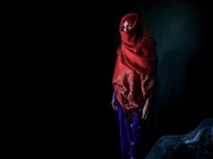 Unveiling the Rich Traditions of Amazigh Culture: A Comprehensive Analysis Amazigh woman in traditional attire surrounded by vibrant tribal accessories