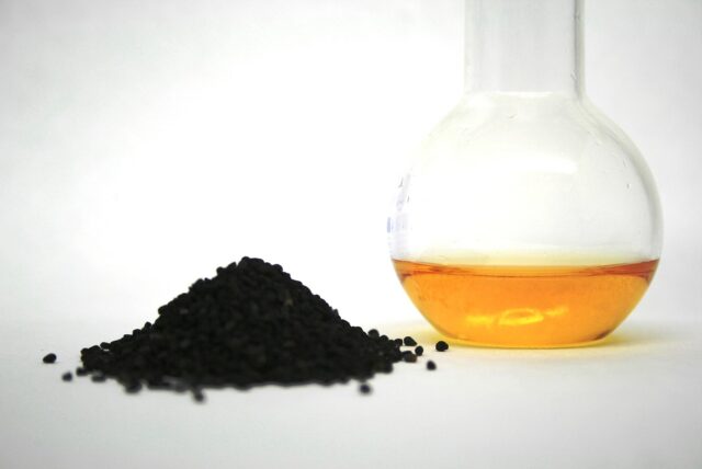 Nigella Seed Oil Hair Care Woman applying nigella seed oil on her hair for natural hair care