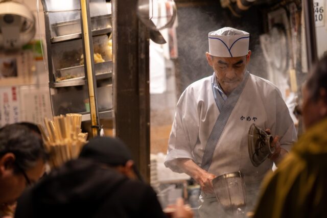 Tunisian chef Malek Labidi cooking Chef Malek Labidi preparing a traditional South Tunisian dish in bustling Tunisian market