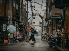 Unveiling the Judeo-Amazigh Cultural Substratum: A Deep Dive for Maghrebi Diaspora Readers Maghrebi woman wearing traditional Judeo-Amazigh jewelry and headpiece in a historic marketplace