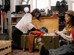 Revitalizing Morocco’s Heritage: Exploring the Blossoming Second-Hand Clothes Market Woman browsing through colorful second-hand clothes at a bustling Moroccan market