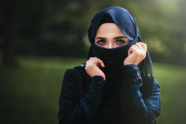 Maghrebi woman in contemporary hijab walking through a fashion market