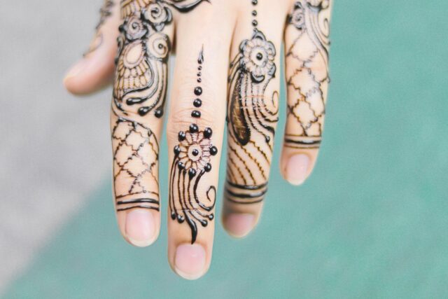 Woman applying henna and nigelle oil in traditional Maghrebi setting