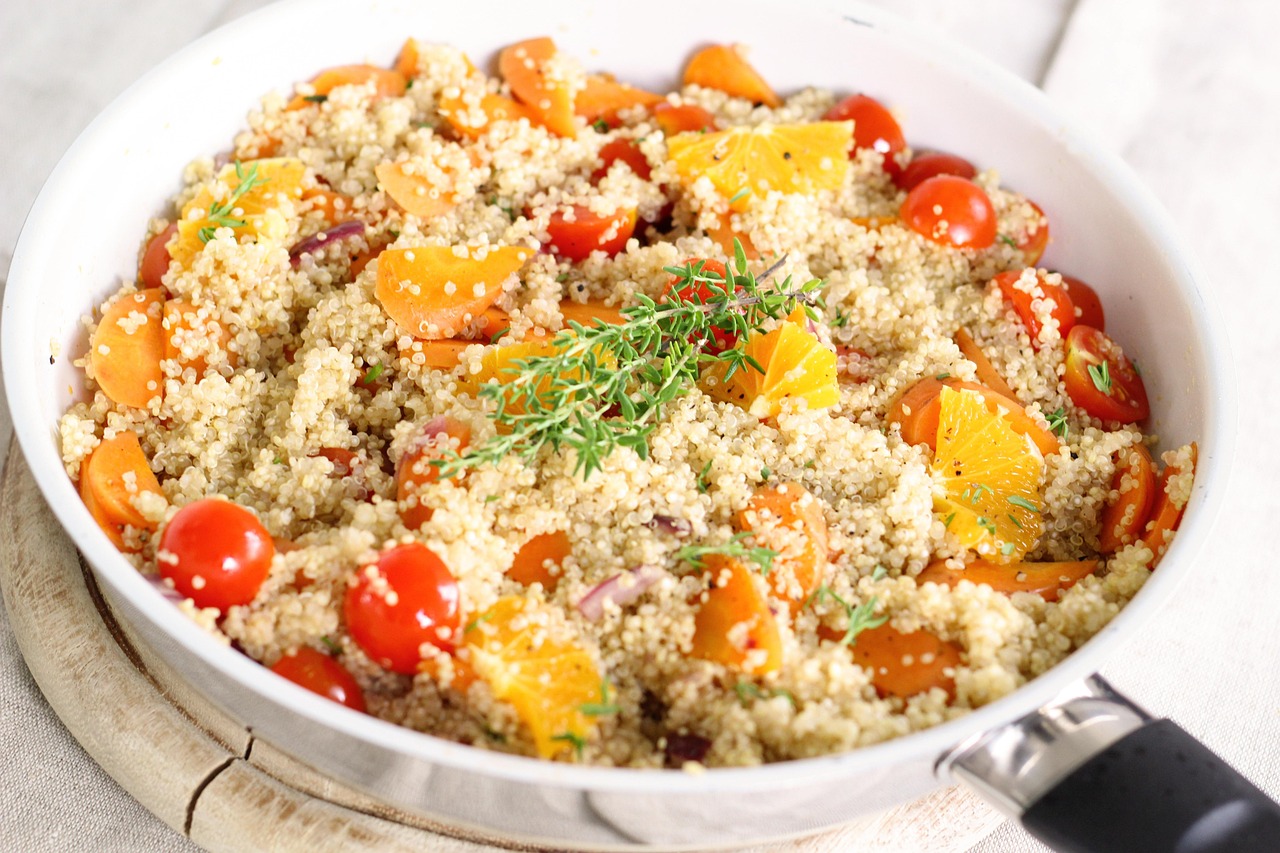 Andrea Buckett's orange-ginger curried couscous salad on a colorful plate with fresh fruits and vegetables